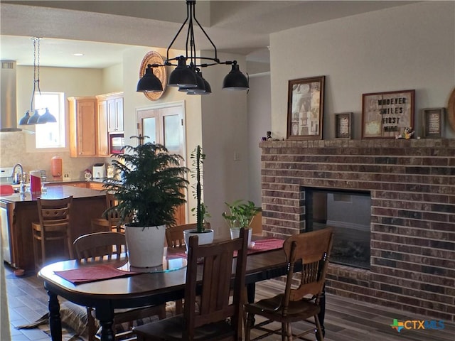 dining space featuring dark hardwood / wood-style flooring, sink, a fireplace, and french doors