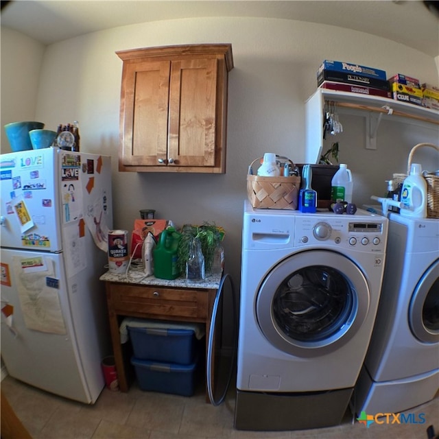 laundry room with cabinets, independent washer and dryer, and light tile patterned floors