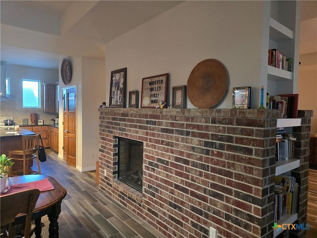 living room with dark hardwood / wood-style flooring and a brick fireplace