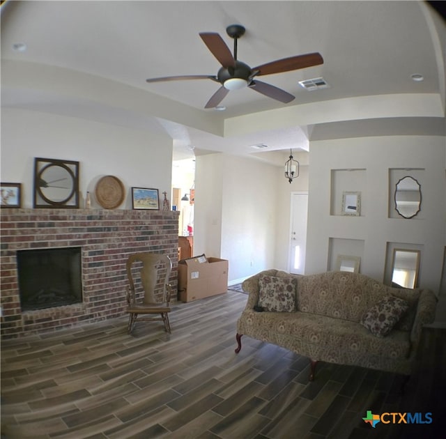 living room featuring ceiling fan and a fireplace