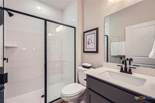 full bathroom with a stall shower, vanity, and toilet