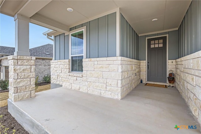 entrance to property with board and batten siding and stone siding