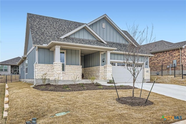 view of front facade with a garage, a shingled roof, fence, and board and batten siding