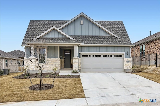 craftsman-style home featuring a shingled roof, central AC, board and batten siding, and a garage