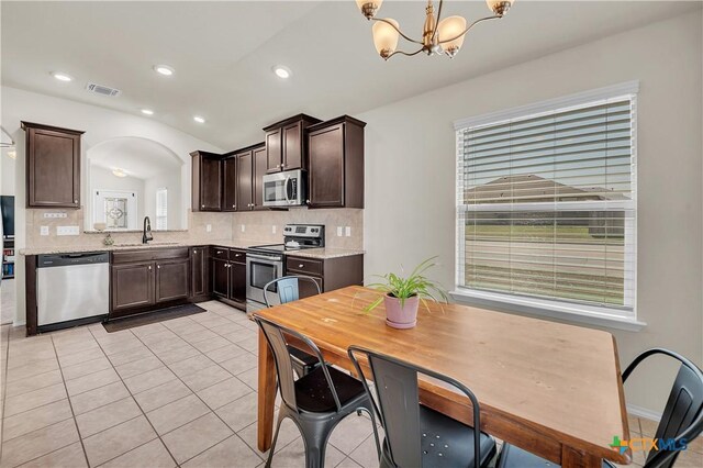 kitchen featuring light tile patterned floors, stainless steel appliances, tasteful backsplash, visible vents, and dark brown cabinetry