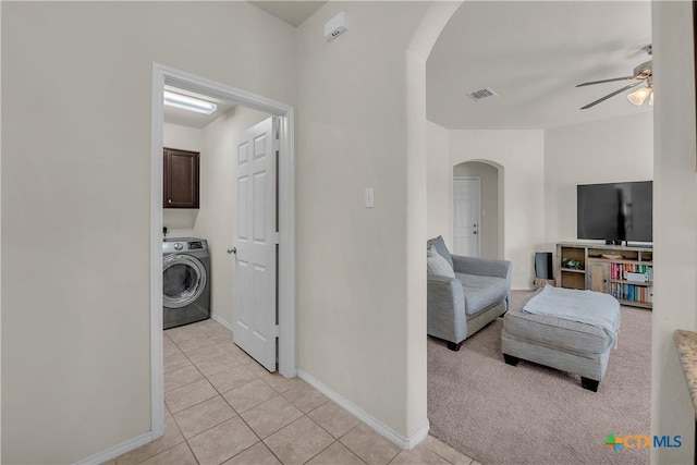 laundry area with arched walkways, cabinet space, visible vents, light tile patterned flooring, and washer / dryer