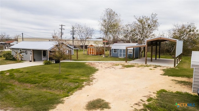 view of yard featuring a carport and a storage unit