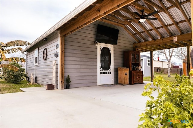 entrance to property with ceiling fan and a patio area