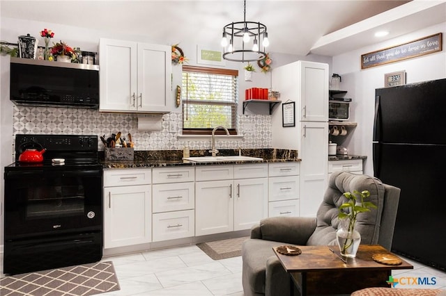 kitchen with decorative backsplash, sink, black appliances, pendant lighting, and white cabinetry