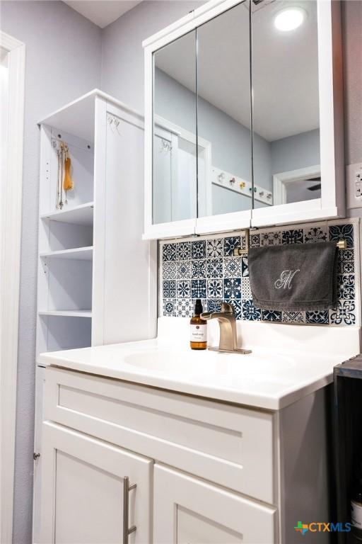 bar with decorative backsplash, white cabinets, and sink