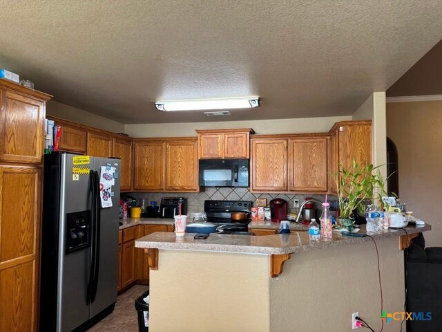 9604 Diana Dr, Killeen, TX 76542 - kitchen with black appliances, a peninsula, brown cabinets, tasteful backsplash, and light countertops