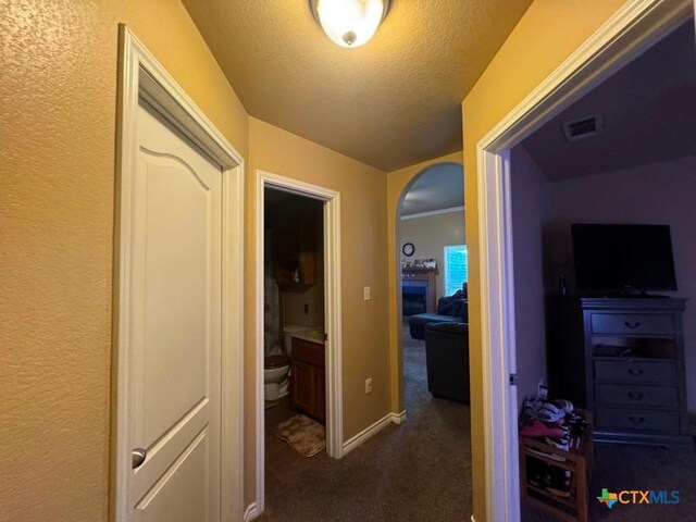 9604 Diana Dr, Killeen, TX 76542 - corridor with arched walkways, dark carpet, a textured ceiling, and baseboards