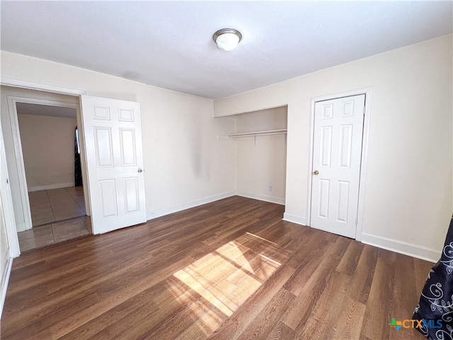 unfurnished bedroom with dark hardwood / wood-style flooring