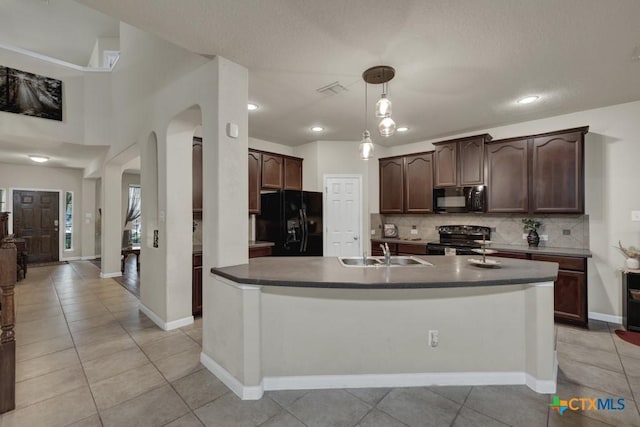 1104 Magellan, Windcrest, TX 78239 - kitchen featuring black appliances, a sink, arched walkways, dark brown cabinets, and decorative backsplash