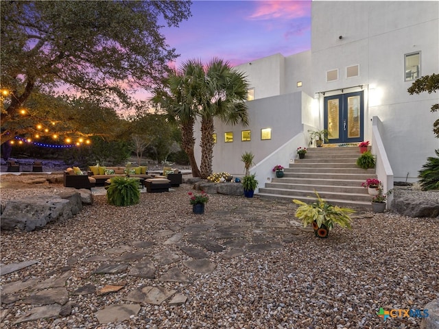 exterior space with a patio area, french doors, and stucco siding