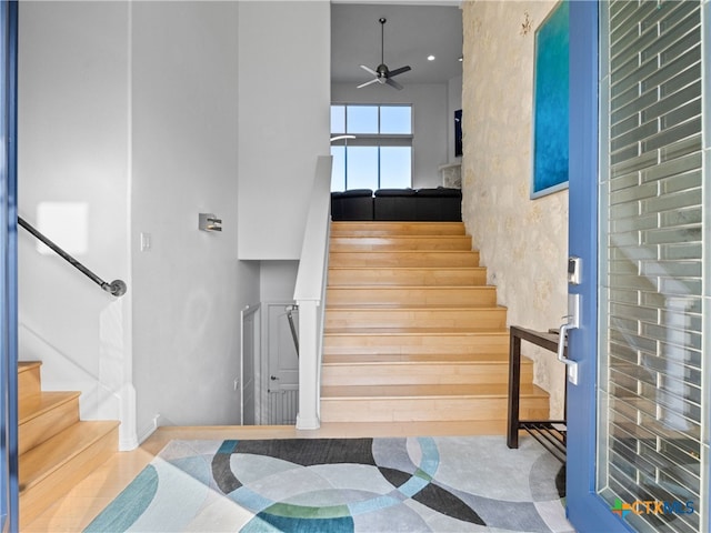 stairs with a high ceiling and a ceiling fan