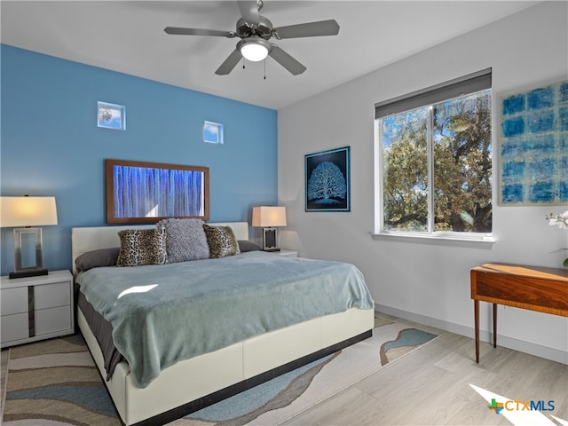 bedroom featuring ceiling fan, baseboards, and wood finished floors