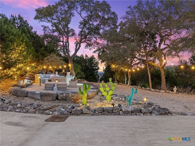 yard at dusk with a patio area and an outdoor hangout area