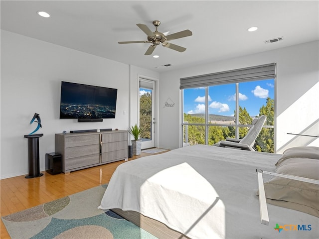 bedroom featuring visible vents, a ceiling fan, wood finished floors, recessed lighting, and access to exterior