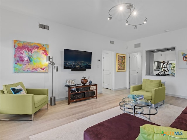 living area featuring a notable chandelier, wood finished floors, and visible vents