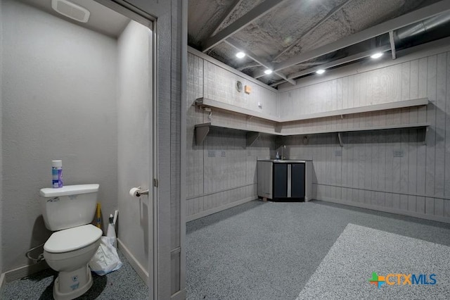bathroom featuring baseboards, a sink, and toilet