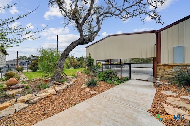exterior space with fence, a gate, and stone siding