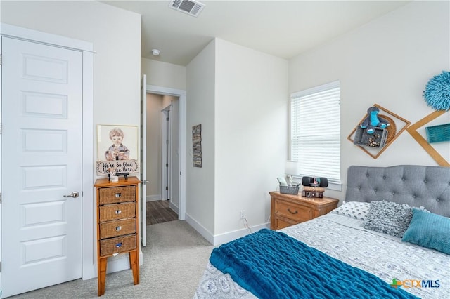 carpeted bedroom featuring visible vents and baseboards