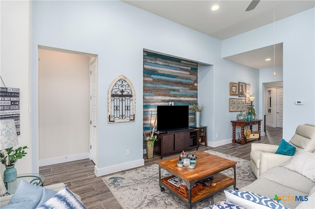 living area featuring recessed lighting, wood finished floors, a ceiling fan, and baseboards