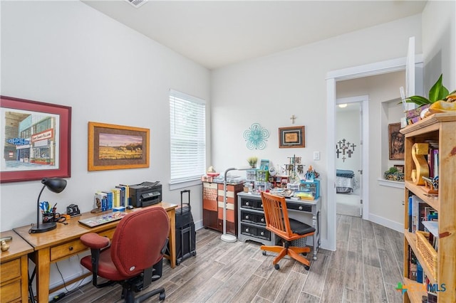 home office with light wood-type flooring and baseboards