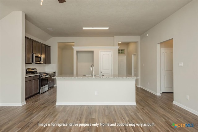 1234 Dowdy Dr, Belton, TX 76513 - kitchen featuring a sink, dark brown cabinetry, wood finished floors, an island with sink, and appliances with stainless steel finishes