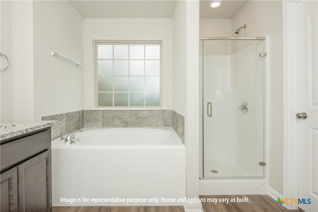 1234 Dowdy Dr, Belton, TX 76513 - bathroom featuring wood finished floors, vanity, a garden tub, and a stall shower