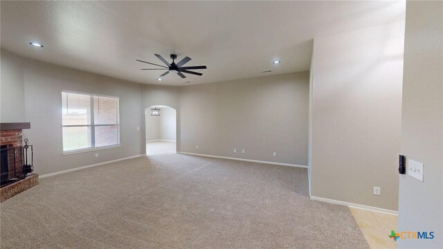 403 Ali Dr, Killeen, TX 76542 - unfurnished living room with a ceiling fan, arched walkways, a brick fireplace, recessed lighting, and light colored carpet