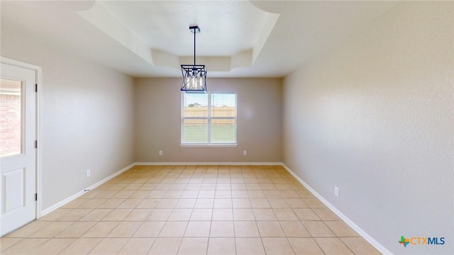 403 Ali Dr, Killeen, TX 76542 - spare room featuring a tray ceiling, baseboards, and light tile patterned floors
