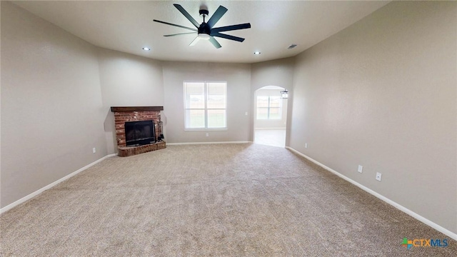 403 Ali Dr, Killeen, TX 76542 - unfurnished living room with arched walkways, a ceiling fan, carpet, a brick fireplace, and baseboards