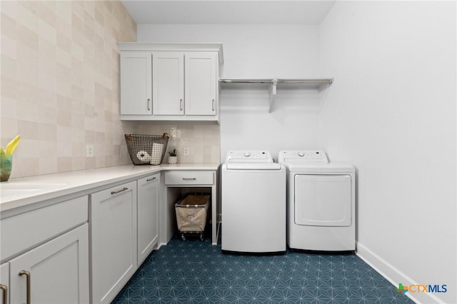 laundry area featuring cabinets, washing machine and dryer, and sink