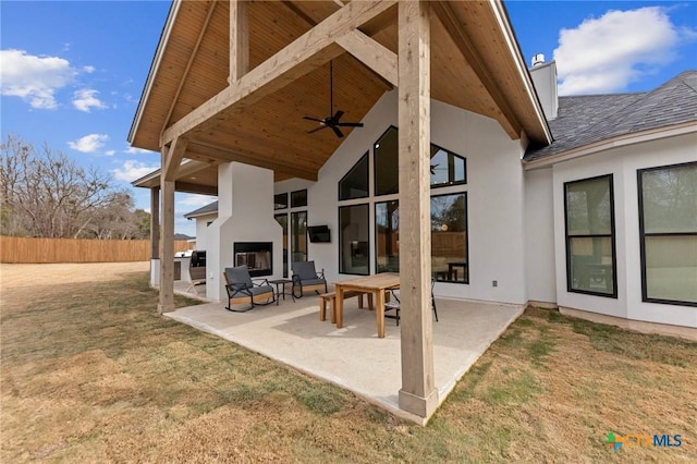 view of patio / terrace featuring ceiling fan and an outdoor fireplace