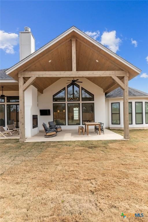 back of house featuring a yard, ceiling fan, and a patio area