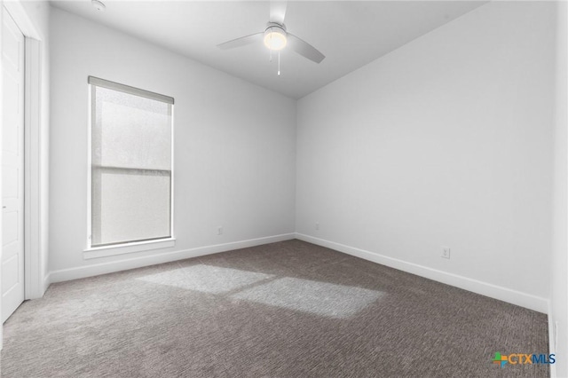 carpeted empty room featuring a healthy amount of sunlight and ceiling fan