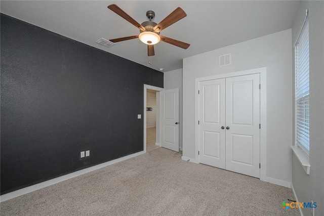 unfurnished bedroom featuring baseboards, a closet, visible vents, and carpet flooring