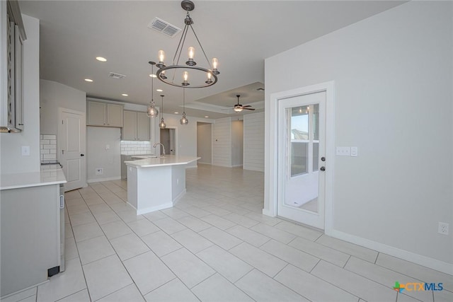 kitchen featuring visible vents, decorative backsplash, a ceiling fan, and gray cabinetry