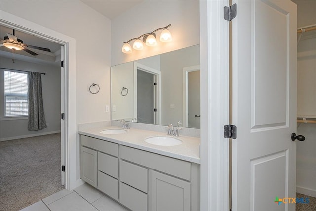 full bath featuring double vanity, tile patterned flooring, a ceiling fan, and a sink