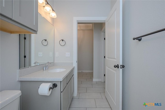 half bathroom featuring toilet, tile patterned floors, and vanity