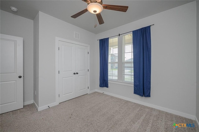 unfurnished bedroom with a ceiling fan, baseboards, visible vents, and carpet flooring