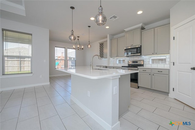 kitchen featuring gray cabinets, visible vents, backsplash, appliances with stainless steel finishes, and a sink