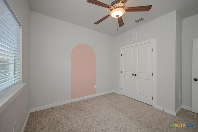 unfurnished bedroom featuring carpet, visible vents, ceiling fan, and baseboards