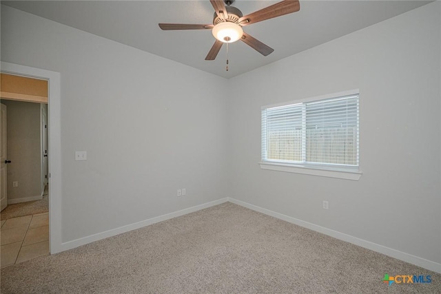 spare room featuring light carpet and baseboards