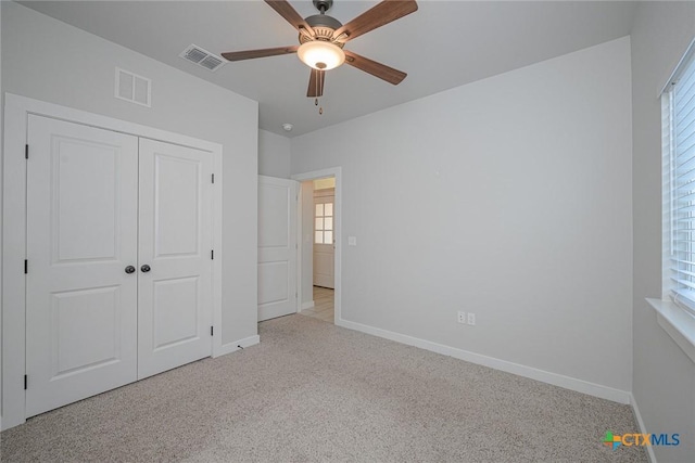 unfurnished bedroom featuring baseboards, visible vents, and light colored carpet