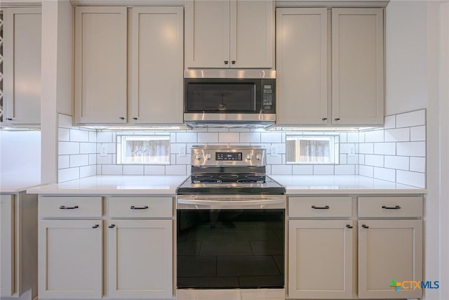 kitchen featuring appliances with stainless steel finishes, light countertops, and tasteful backsplash