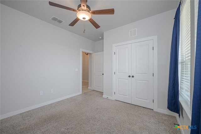 unfurnished bedroom with carpet floors, a closet, visible vents, and baseboards