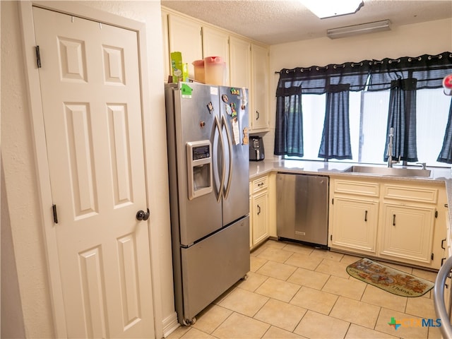 kitchen featuring stainless steel appliances, a textured ceiling, and sink